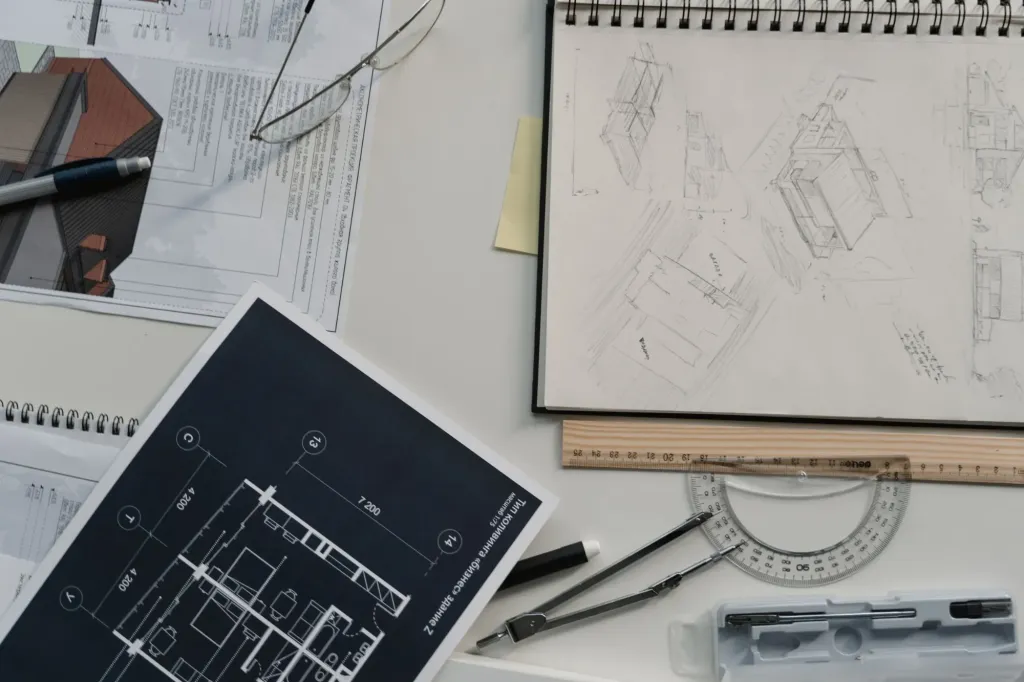 Architectural sketches and a drawing sheet with a ruler and protractor